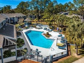 Jacksonville apartment for rent - A swimming pool surrounded by a fence and chairs.
