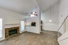 Tyler apartment for rent - an empty living room with a fireplace and a ceiling fan