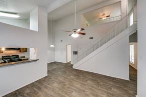 Tyler apartment for rent - the living room and entryway of a house with white walls and a ceiling fan