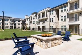 Georgetown townhouse for rent - A fire pit with blue chairs in front of apartment buildings.