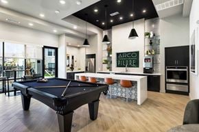 Georgetown townhouse for rent - A black pool table is in the middle of a room with a bar and a kitchen in the background.