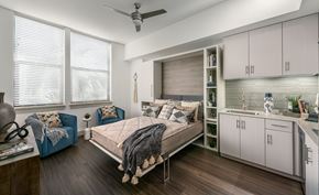 Phoenix apartment for rent - A bedroom with a bed, a chair, and a fan.