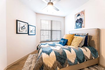 Pflugerville apartment for rent - A bedroom with a bed, pillows, and pictures on the wall.