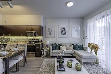 Miami apartment for rent - A modern kitchen with a dining table and a couch in the living room.