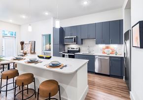 Houston apartment for rent - A modern kitchen with a bar area and a dining table set for two.