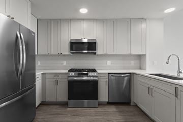 Atlanta apartment for rent - A modern kitchen with a stainless steel refrigerator and white cabinets.