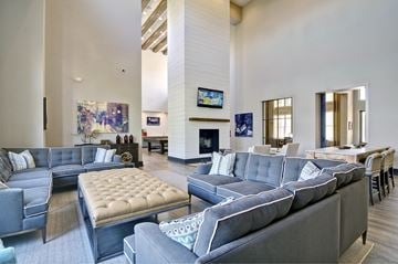 Phoenix apartment for rent - a large living room with blue couches and chairs and a fireplace