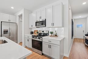 Braselton apartment for rent - A modern kitchen with white cabinets and stainless steel appliances.