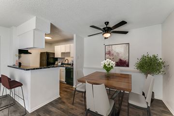 Longview apartment for rent - an open kitchen and dining area with a table and chairs and a ceiling fan
