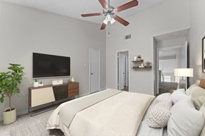 San Antonio townhouse for rent - A bedroom with a large bed, a television, and a ceiling fan.