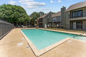 San Antonio townhouse for rent - A swimming pool surrounded by a fence and a building in the background.