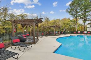 Concord apartment for rent - A pool area with a wooden pergola and lounge chairs.