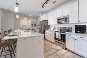 Denison apartment for rent - a large kitchen with white cabinets and stainless steel appliances