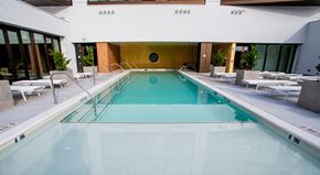 Atlanta apartment for rent - A large indoor swimming pool with lounge chairs on the side.