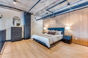 Dallas apartment for rent - A bedroom with a bed, nightstands, and a wooden floor.