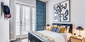 Fort Worth apartment for rent - A bedroom with a large bed and a painting on the wall.
