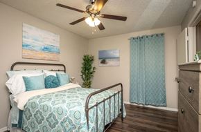 Dallas apartment for rent - a bedroom with a bed and a ceiling fan
