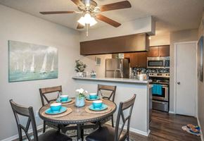 Dallas apartment for rent - a dining area with a table and chairs and a kitchen in the background