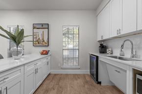 Austin apartment for rent - A kitchen with white cabinets and a wooden floor.