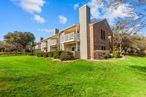 Austin apartment for rent - A large grassy area in front of a building with a balcony.