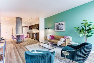 Chicago apartment for rent - A living room with a blue chair and a green plant.