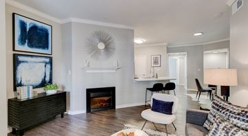 Flower Mound apartment for rent - A living room with a fireplace and a painting on the wall.