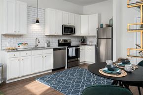 Cincinnati apartment for rent - A kitchen with white cabinets and a black countertop.