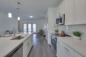 Nashville apartment for rent - A modern kitchen with white cabinets and a wooden floor.
