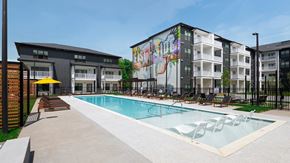 Nashville apartment for rent - A pool in front of a building with a mural on the side.