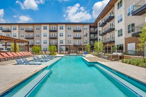 Fort Worth apartment for rent - A swimming pool in front of apartment buildings.
