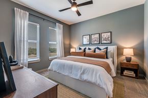 Fort Worth apartment for rent - A bedroom with a large bed and a ceiling fan.