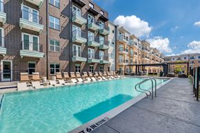 Fort Worth apartment for rent - A swimming pool is surrounded by apartment buildings.