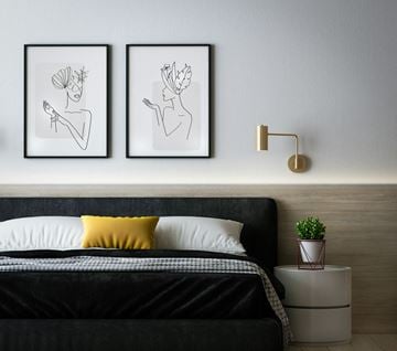 Amarillo apartment for rent - A bedroom with a black bed and two framed drawings above it.