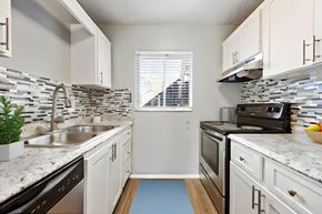 Fort Myers apartment for rent - a kitchen with white cabinets and granite counter tops and a sink