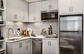 Phoenix apartment for rent - A modern kitchen with stainless steel appliances and white cabinets.