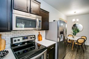 Las Vegas apartment for rent - A kitchen with a stove, oven, microwave, refrigerator, and a dining table with chairs.
