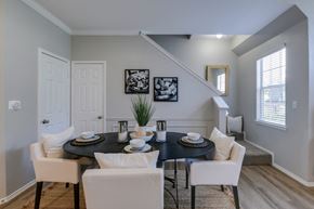 Plano apartment for rent - A dining room with a black table and white chairs.