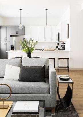 Elkhorn townhouse for rent - A grey couch with a black pillow and a vase with flowers on a coffee table.