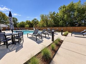Moore apartment for rent - A poolside area with chairs and a table.