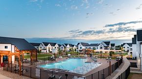 Leander apartment for rent - A large outdoor swimming pool surrounded by a fence and a wooden pergola.