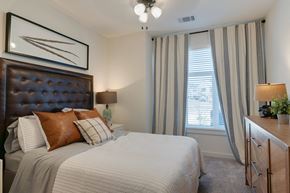 Leander apartment for rent - A bedroom with a large bed and a painting above it.