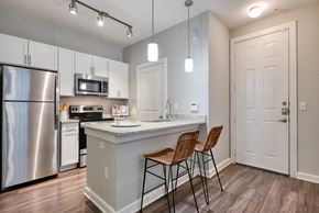 San Antonio apartment for rent - A kitchen with a stainless steel refrigerator and a white countertop.
