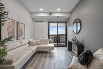 Oakdale apartment for rent - A modern living room with a white couch and a round mirror on the wall.