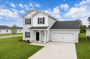 Pooler apartment for rent - A two-story house with a garage is surrounded by a well-kept lawn.