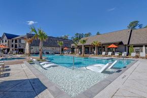 Conroe apartment for rent - A pool with a slide and a building in the background.