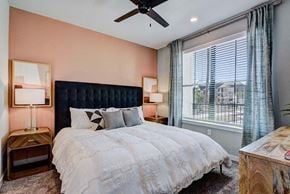Conroe apartment for rent - A bedroom with a large bed and a ceiling fan.