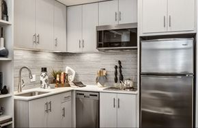 Phoenix apartment for rent - A modern kitchen with a stainless steel refrigerator and white cabinets.