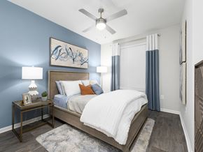 Jacksonville apartment for rent - A bedroom with a bed, nightstand, and a ceiling fan.