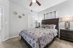 San Antonio apartment for rent - A bedroom with a bed, dresser, and ceiling fan.