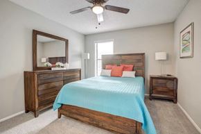 Jacksonville apartment for rent - a bedroom with a bed and a ceiling fan